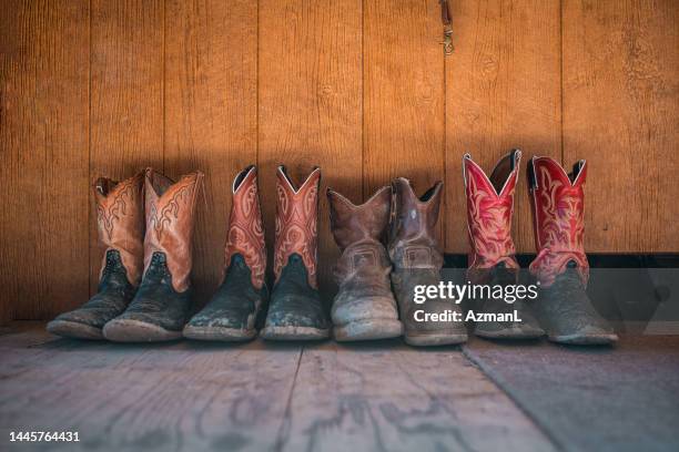 cowboy boots against wooden wall - cowboy boots stock pictures, royalty-free photos & images