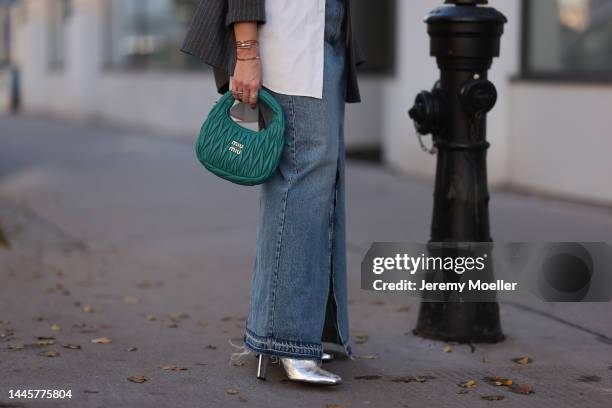 Karin Teigl is seen wearing Balenciaga white button shirt, Miu Miu Hobo turquoise bag, H&M striped grey oversized blazer, Zara long denim skirt and...