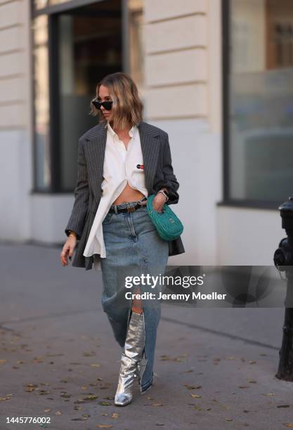 Karin Teigl is seen wearing Balenciaga white button shirt, Miu Miu Hobo turquoise bag, H&M striped grey oversized blazer, Dior black leather gold...