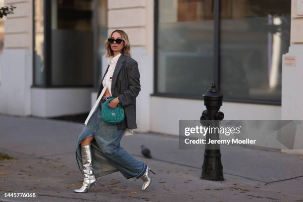 Karin Teigl is seen wearing Balenciaga white button shirt, Miu Miu Hobo turquoise bag, H&M striped grey oversized blazer, Dior black leather gold...