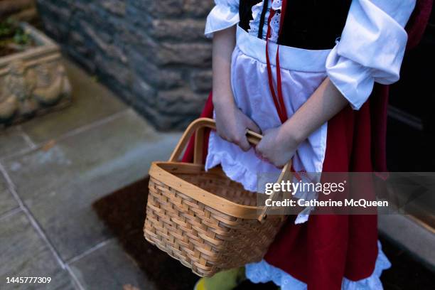 trick or treat: young mixed-race girl dressed in traditional storybook character costume - apron eyelets foto e immagini stock