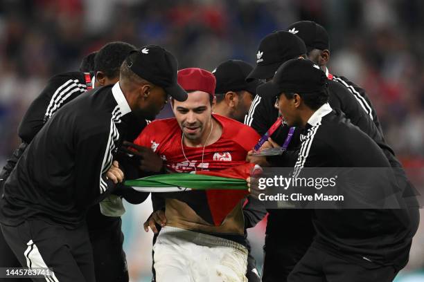 Pitch invader is apprehended by security during the FIFA World Cup Qatar 2022 Group D match between Tunisia and France at Education City Stadium on...