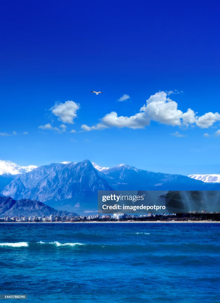 Seascape with high mountains and Antalya cityscape view