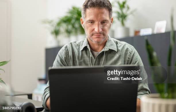 businessman talking on a video call using a laptop computer in the office - employee engagement stock pictures, royalty-free photos & images