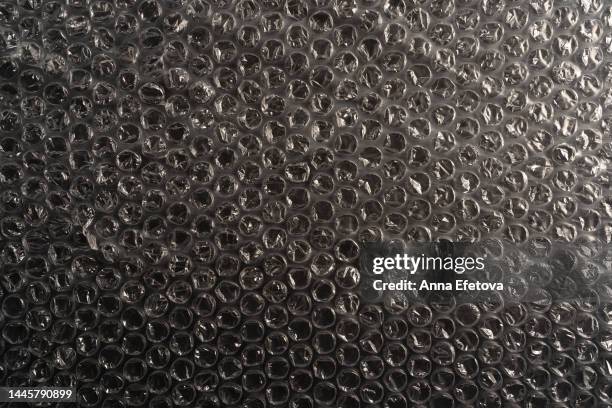 textured black bubble wrap for packaging. using unsustainable materials harms the planet. background for your design with copy space - polietilene foto e immagini stock