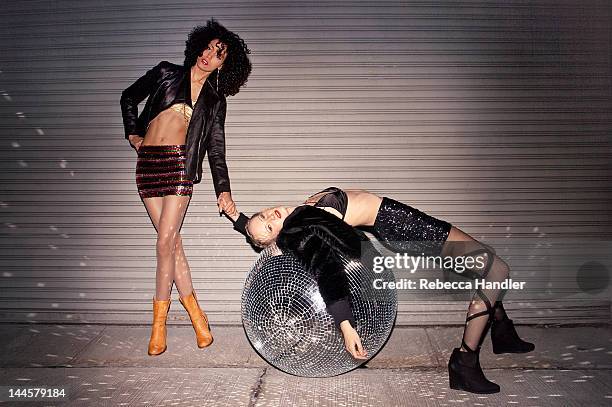 two ladies on street with huge disco ball at night - woman party fotografías e imágenes de stock