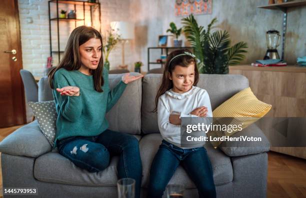 mother scolding her daughter at home - stressed young woman sitting on couch stock pictures, royalty-free photos & images