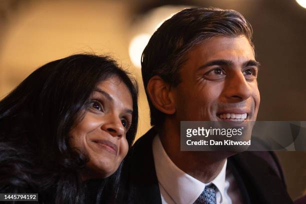 Prime Minister Rishi Sunak and his wife Akshata Murty look at stands during a Christmas Market event on Downing Street on November 30, 2022 in...