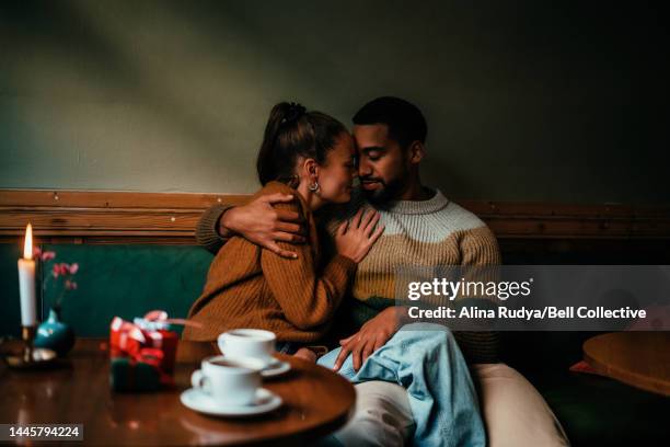 young couple hugging in a cafe - coffee shop couple stock pictures, royalty-free photos & images
