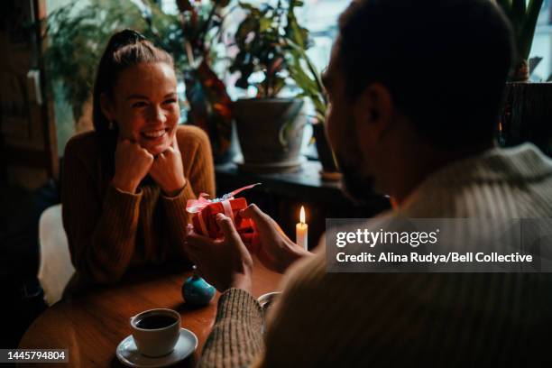 young woman receiving a gift - exchanging gifts stock pictures, royalty-free photos & images