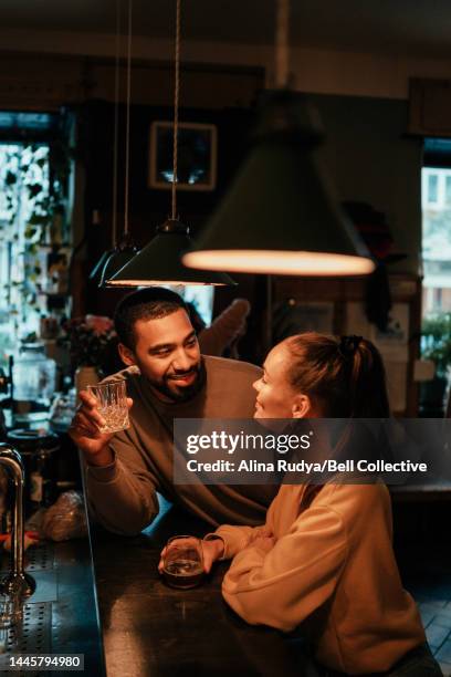 young couple on a date at a bar - flirting stock pictures, royalty-free photos & images