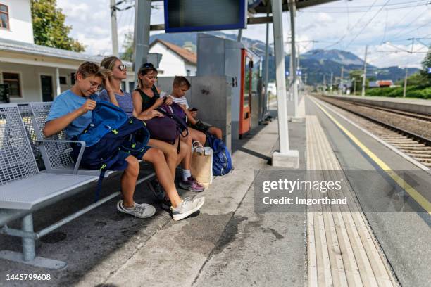 famille attendant le train à la gare - quai de gare photos et images de collection
