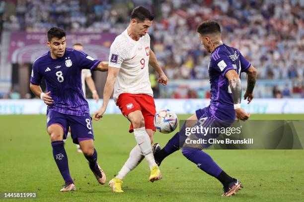 Robert Lewandowski of Poland is challenged by Marcos Acuna and Enzo Fernandez of Argentina during the FIFA World Cup Qatar 2022 Group C match between...