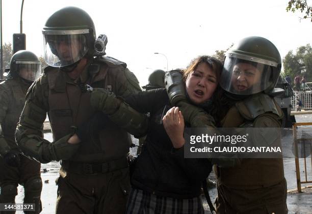 Riot police officers arrest a student during a march in Santiago to demand that President Sebastian Pinera's government overhaul the education system...