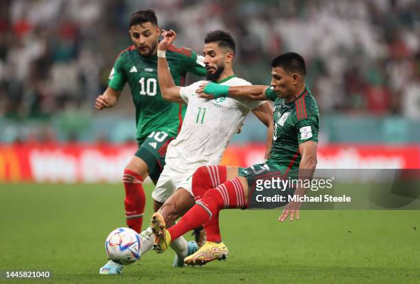 Saleh Al-Shehri of Saudi Arabia controls the ball under pressure of Alexis Vega and Jesus Gallardo of Mexico during the FIFA World Cup Qatar 2022...