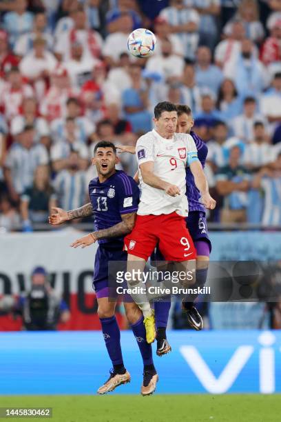 Robert Lewandowski of Poland jumps for the ball with Cristian Romero and German Pezzella of Argentina during the FIFA World Cup Qatar 2022 Group C...