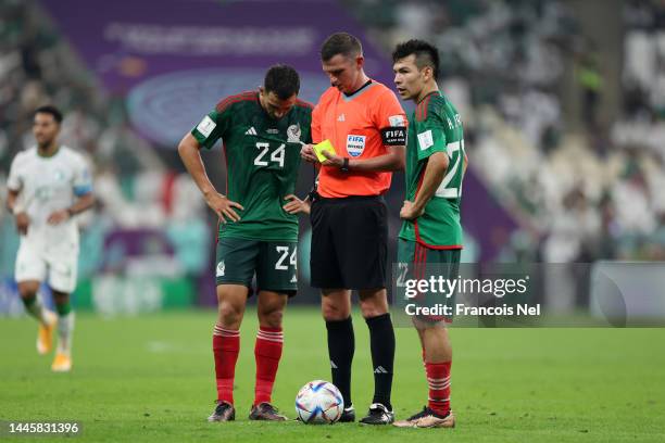 Luis Chavez and Hirving Lozano of Mexico react as referee Michael Oliver prepares a yellow card during the FIFA World Cup Qatar 2022 Group C match...