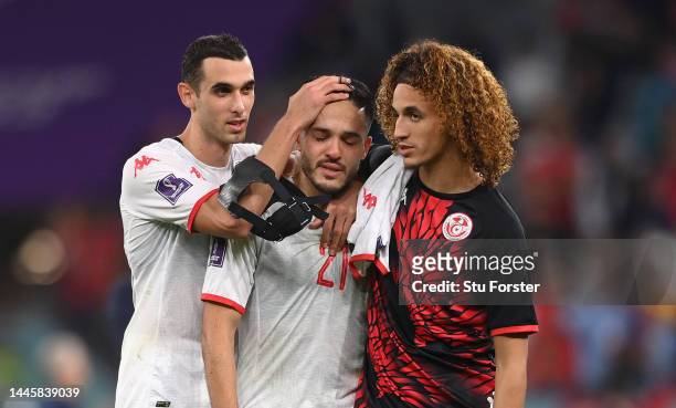 Wajdi Kechrida of Tunisia is consoled by team mates Ellyes Skhiri and Hannibal Mejbri after the FIFA World Cup Qatar 2022 Group D match between...