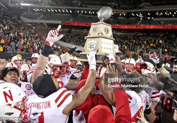 The Nebraska Cornhuskers celebrate with the Heroes Trophy after the match-up against the Iowa Hawkeyes at Kinnick Stadium, on November 25, 2022 in...