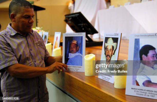 The son of Modesto Munera Posada Osorio murdered on October 25, 1997 in the El Aro massacre holds a photo during a speech to ask forgiveness on...