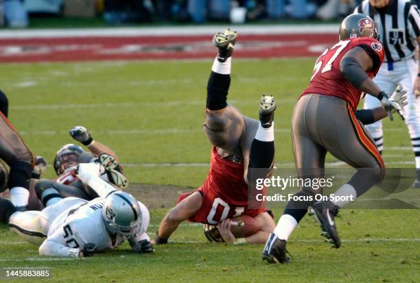 Mike Alstott of the Tampa Bay Buccaneers gets tackled by Eric Barton of the Oakland Raiders in Super Bowl XXXVII at Qualcomm Stadium on January 26,...