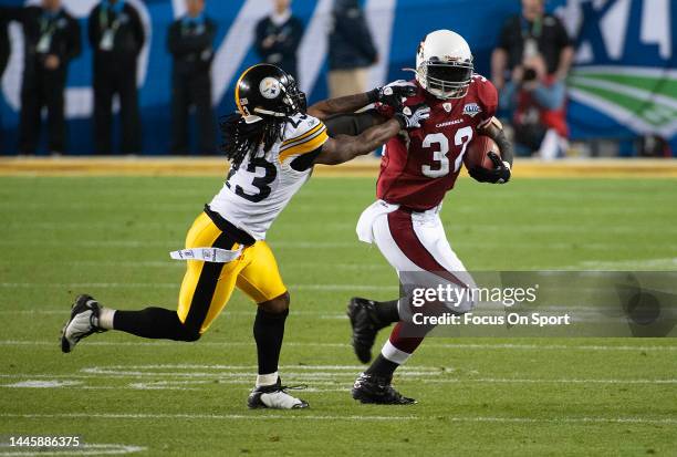 Edgerrin James of the Arizona Cardinal fights off the tackle of Tyrone Carter of the Pittsburgh Steeler in Super Bowl XLIII on February 1, 2009 at...