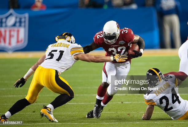 Edgerrin James of the Arizona Cardinal gets tackled by James Farrior and Ike Taylor of the Pittsburgh Steeler in Super Bowl XLIII on February 1, 2009...