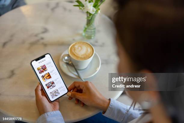 woman at a cafe looking at a digital menu - phone order stock pictures, royalty-free photos & images