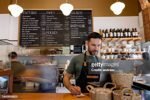 kellner arbeitet in einem café und schreibt eine online-bestellung auf - kitchen bar stock-fotos und bilder