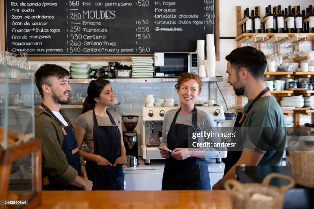 Business manager talking to her staff at a cafe