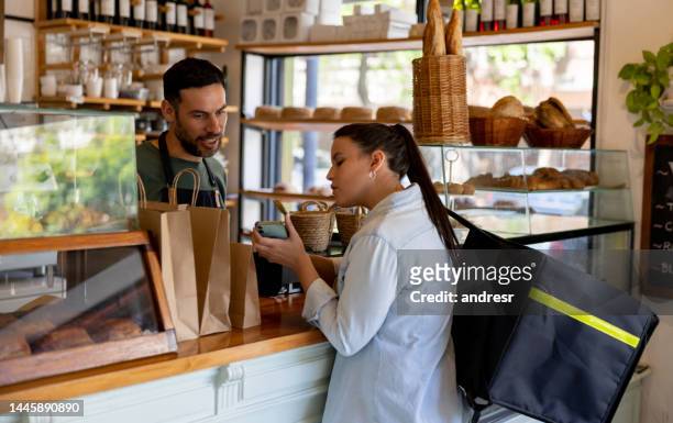 food delivery person picking up an order at a cafe - picking up coffee stock pictures, royalty-free photos & images
