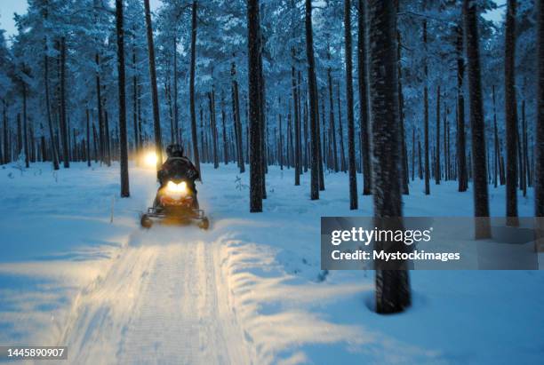 man driving a snowmobile in sweden - snowmobile stock pictures, royalty-free photos & images