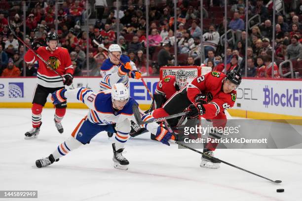 Derek Ryan of the Edmonton Oilers and Caleb Jones of the Chicago Blackhawks battle for the puck during the first period at United Center on November...