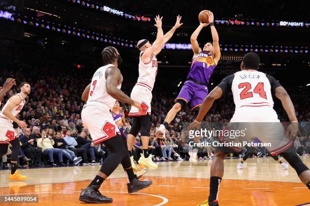 Devin Booker of the Phoenix Suns puts up a shot over Alex Caruso of the Chicago Bulls during the first half of the NBA game at Footprint Center on...