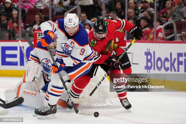 Connor McDavid of the Edmonton Oilers and Colin Blackwell of the Chicago Blackhawks battle for the puck in front of the net during the second period...