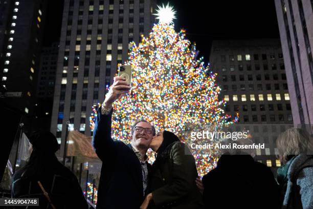People take selfeis with the newly lit Christmas tree at the 90th annual Rockefeller Christmas Tree lighting on November 30, 2022 in New York City....