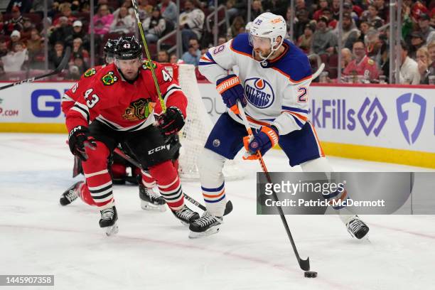 Leon Draisaitl of the Edmonton Oilers skates with the puck against Colin Blackwell of the Chicago Blackhawks during the third period at United Center...