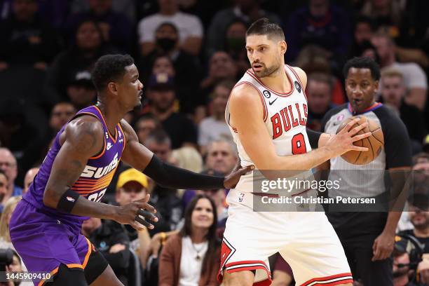 Nikola Vucevic of the Chicago Bulls handles the ball against Deandre Ayton of the Phoenix Suns during the first half of the NBA game at Footprint...