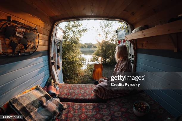 woman enjoys coffee from her van - magenta car stock pictures, royalty-free photos & images