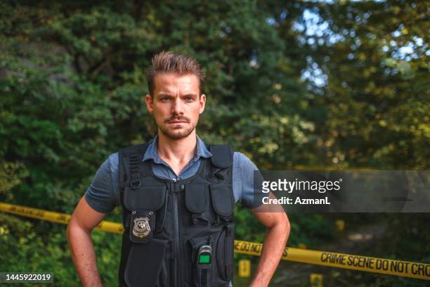 stern mid adult caucasian detective in protective vest at a crime scene - bulletproof stock pictures, royalty-free photos & images