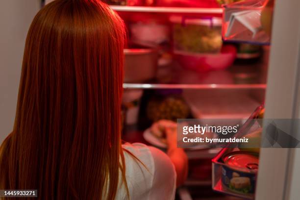 mulher fazendo escolhas sobre o que comer tarde da noite - bulimia nervosa - fotografias e filmes do acervo