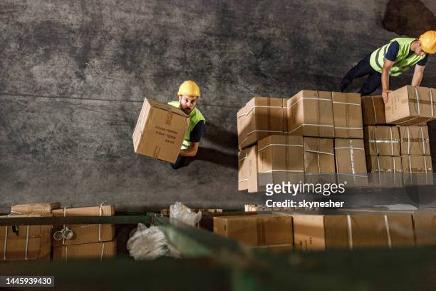above view of manual workers working in distribution warehouse. - packaging bildbanksfoton och bilder