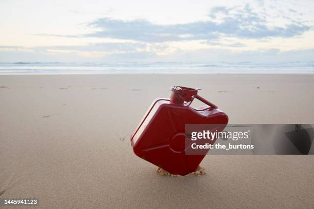 red gas can at beach during sunset - can beach sun photos et images de collection