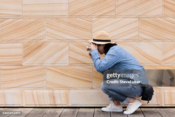 femme à l’extérieur prenant une photo avec son appareil photo - accroupi profil photos et images de collection
