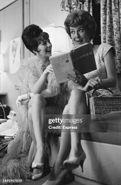 American actress Natalie Wood and American burlesque dancer Louise Hovick , who holds a copy of her book, during a break in filming of the musical...