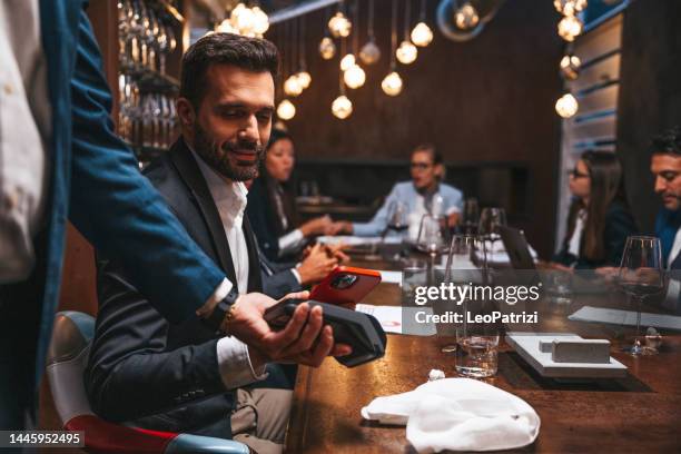 empresario pagando almuerzo de trabajo usando el pago de la aplicación móvil sin contacto - comida de negocios fotografías e imágenes de stock