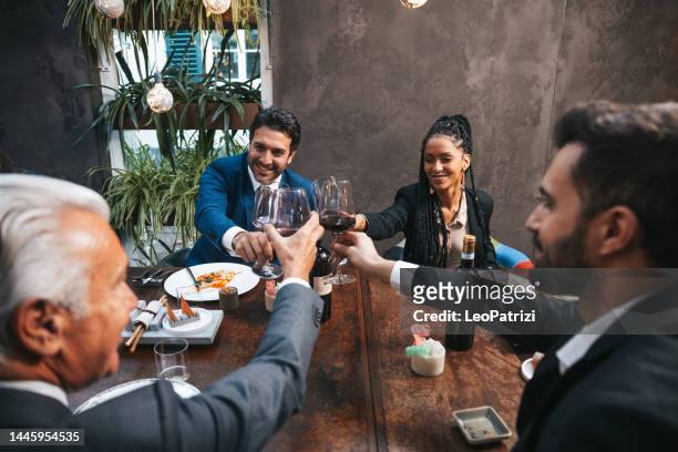 persone in affari che brindano dopo una riunione in un ristorante - shareholder foto e immagini stock