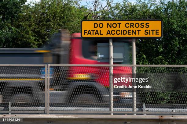 Lorry drives past a road warning safety sign that reads "Do Not Cross Fatal Accident Site" on the A127 on July 3, 2023 in Basildon, England.