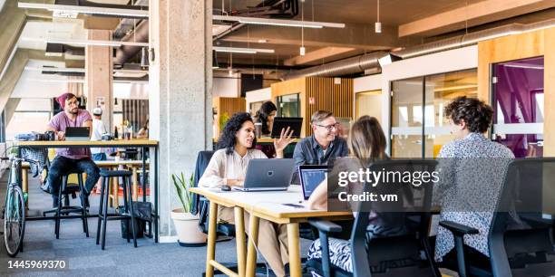 unternehmer bei einem meeting im büro - coworking office stock-fotos und bilder