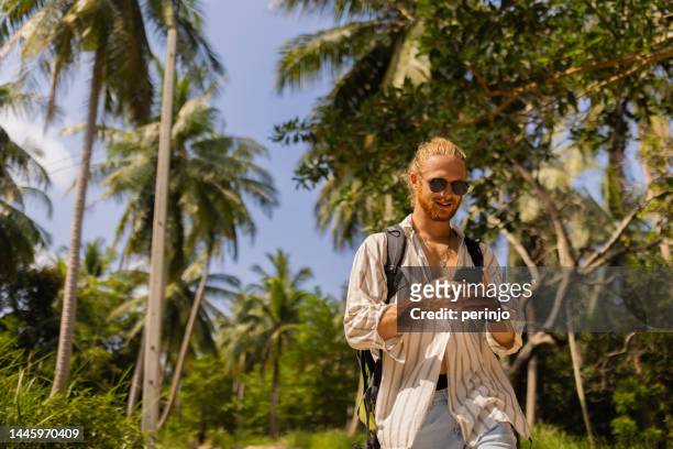 männlicher tourist mit handy zur orientierung auf alleinreise - jungle safari stock-fotos und bilder